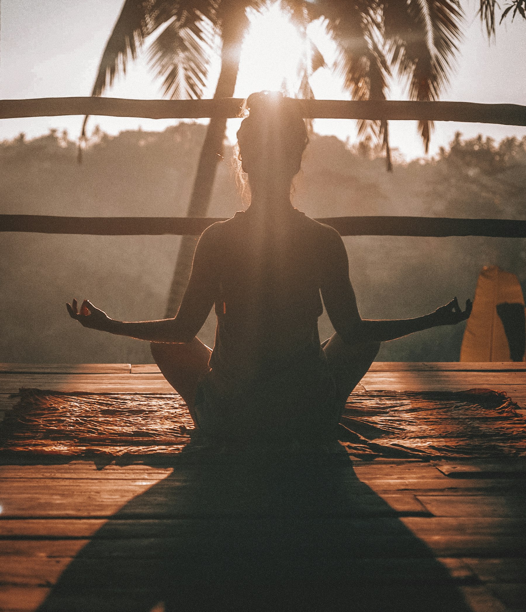 A practitioner seated in meditation at first light, bathed in warm golden sun